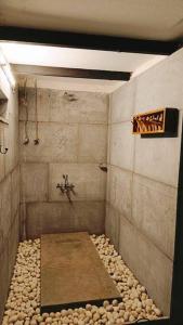 La salle de bains est pourvue d'une douche avec des rochers. dans l'établissement Zephyr - In The Sky, à Khamshet