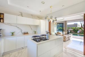 eine Küche mit weißen Schränken und einem Herd in der Unterkunft Palais Rafi in Marrakesch