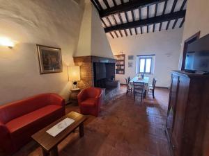 sala de estar con sofá y chimenea en Podere Il Caggio Rooms, en San Gimignano