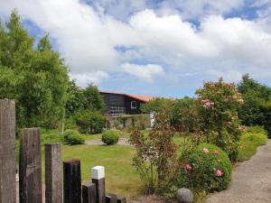 una cerca frente a una casa con flores en De Vrijheid-Plantage, en De Cocksdorp