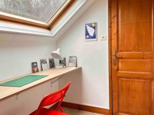 Zimmer mit einem Schreibtisch mit einem roten Stuhl und einem Fenster in der Unterkunft La Maison des Papillons - Nargis in Nargis