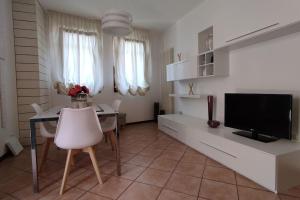 uma sala de estar com uma televisão e uma mesa e cadeiras em residenza 7 martiri 028060-LOC-01585 em Pádua