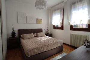 um quarto com uma cama e duas janelas em residenza 7 martiri 028060-LOC-01585 em Pádua