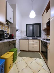 a kitchen with white cabinets and a tv on the counter at Casa Velasquez in Palermo