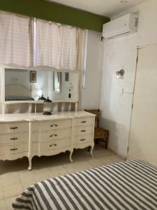 1 dormitorio con tocador blanco y espejo en Villa Covadonga, en Acapulco