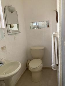 ein kleines Badezimmer mit Toilette und Waschbecken in der Unterkunft Villa Covadonga in Acapulco + 30 Fotos