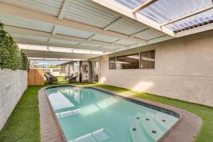 an indoor swimming pool in a house with an open ceiling at Spacious Chula Vista Home with Heated Pool and Hot Tub in Chula Vista