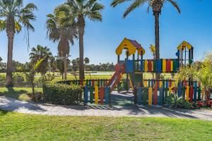 un parque infantil con palmeras en Apartamento Dos Mares, en Motril