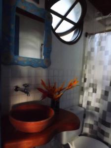 uma casa de banho com um lavatório, um WC e uma janela. em Pousada Cavallitos d'Amar na Ilha de Boipeba