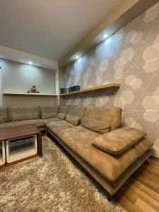 a living room with a brown couch and a table at Luxury private House, near center in Pristina