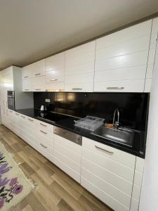 a kitchen with white cabinets and a sink at Luxury private House, near center in Pristina