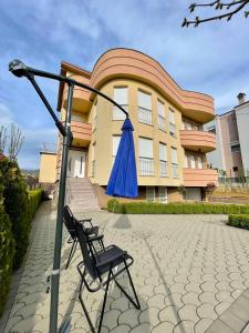 a chair with an umbrella in front of a building at Luxury private House, near center in Pristina