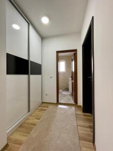 a hallway with white walls and a door to a bathroom at Luxury private House, near center in Pristina