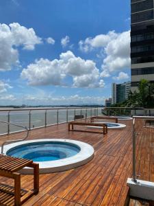 una terraza con bañera de hidromasaje y bancos en una playa en Puerto Santa Ana, Torres Bellini, 2 dormitorios, Parqueo en Guayaquil