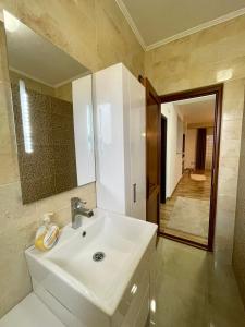 a bathroom with a white sink and a mirror at Luxury private House, near center in Pristina