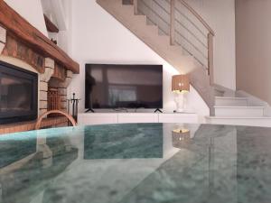 einen Pool in einem Haus mit einem TV und einer Treppe in der Unterkunft La Ribambelle maison 10 personnes au calme in Tendon