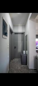 um quarto com uma casa de banho com um lavatório e uma porta em Sountou home em Xanthi