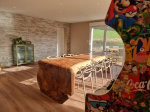 einen großen Holztisch mit Stühlen in einem Zimmer in der Unterkunft La Ribambelle maison 10 personnes au calme in Tendon