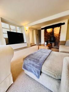 sala de estar amplia con sofá y TV en Large room in Stunning Cottage Edge of the Cotswolds, en Bloxham