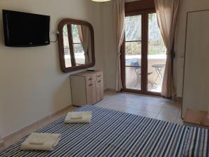 a bedroom with a bed and a mirror and a television at Irina apartment Afitos in Afitos