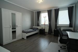 um pequeno quarto com uma cama e uma janela em Fit&Chill Apartment Sport, Entspannung & Netflix em Leipzig