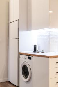 テッサロニキにあるCouple-in magical suite with jacuzziの白い冷蔵庫、洗濯機付きのキッチンが備わります。