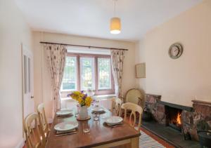 a dining room with a table and a fireplace at 3 Bed in Eskdale SZ403 in Santon Bridge