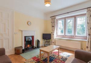 a living room with a fireplace and a table at 3 Bed in Eskdale SZ403 in Santon Bridge