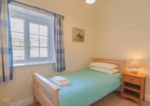 a bedroom with a bed and a window at 3 Bed in Eskdale SZ403 in Santon Bridge