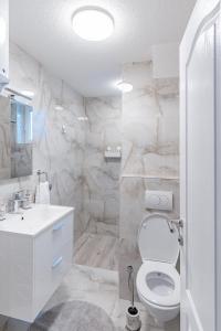 a white bathroom with a toilet and a sink at Mona Visoko in Visoko +17 photos