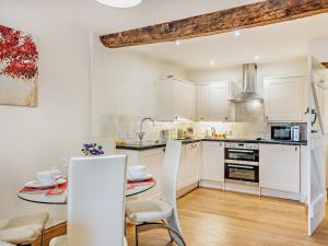 a kitchen with white cabinets and a table with chairs at 2 Bed in Church Stretton 76622 in Rushbury