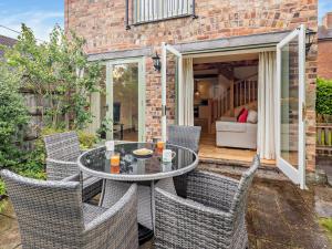 a patio with a table and wicker chairs at 2 Bed in Church Stretton 76622 in Rushbury