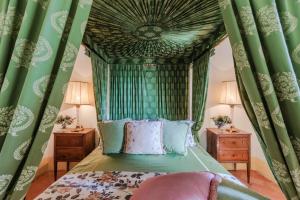 1 dormitorio con cama con dosel y cortinas verdes en Rocca di Cetona - a Medieval Castle, en Cetona 148 fotos más