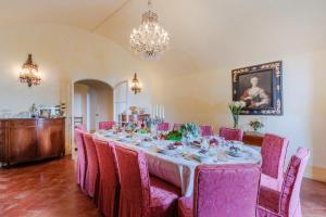 un comedor con una mesa larga con sillas rosas en Rocca di Cetona - a Medieval Castle, en Cetona