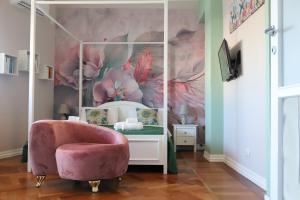 um quarto com uma cadeira rosa e um espelho em Accademia Apartment em Sassari