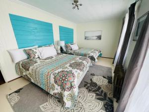 two beds in a bedroom with blue and white walls at Historical Hotel - House of Ludington in Escanaba