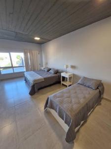 een slaapkamer met twee bedden en een bank erin bij Austral Lofts in Puerto Madryn