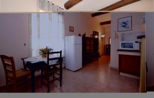 eine Küche mit einem Tisch und einem weißen Kühlschrank in der Unterkunft Lovely Home In Crillon Le Brave With Outdoor Swimming Pool in Crillon-le-Brave