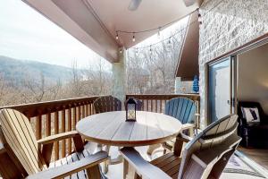 a table and chairs on a balcony with a view at Eagles Nest Escape in Gatlinburg