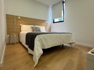 1 dormitorio con 1 cama grande y cabecero de madera en Living PDL 1, en Ponta Delgada