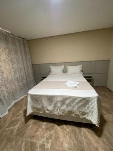 a bedroom with a large bed with a white blanket at Chalé da Montanha in Igaporã +1 photo