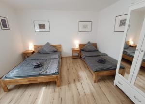 Zimmer mit 2 Betten und einem Spiegel in der Unterkunft Ferienwohnung am Rathaus in Landstuhl
