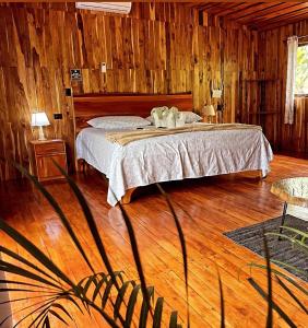 a bedroom with a bed and a wooden floor at Cacahua Paradise Lodge, Río Celeste in Rio Celeste