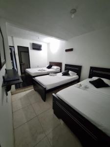 Habitación con 3 camas y chimenea. en Hotel Mayte en Fonseca