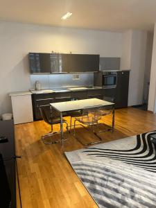 uma cozinha com mesa e cadeiras num quarto em Al Nafurah Apartments em Munique