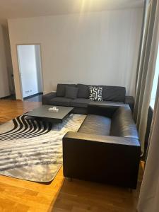 uma sala de estar com um sofá e uma mesa de centro em Al Nafurah Apartments em Munique