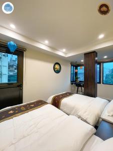 1 dormitorio con 2 camas y ventana en It Dust Homestay 3 - The Indochine Apartment, en Hanói