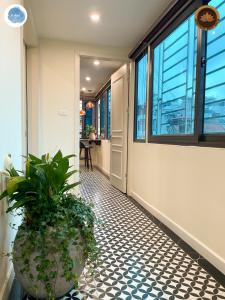 un pasillo con una maceta en el suelo de baldosa en It Dust Homestay 3 - The Indochine Apartment, en Hanói