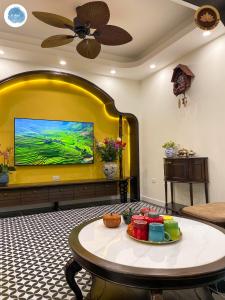 sala de estar con mesa y pared amarilla en It Dust Homestay 3 - The Indochine Apartment, en Hanói