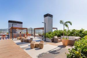 un patio con divani e tavoli su un edificio di Studio Life Experience, Netflix, Pool, Rooftop a Porto Alegre